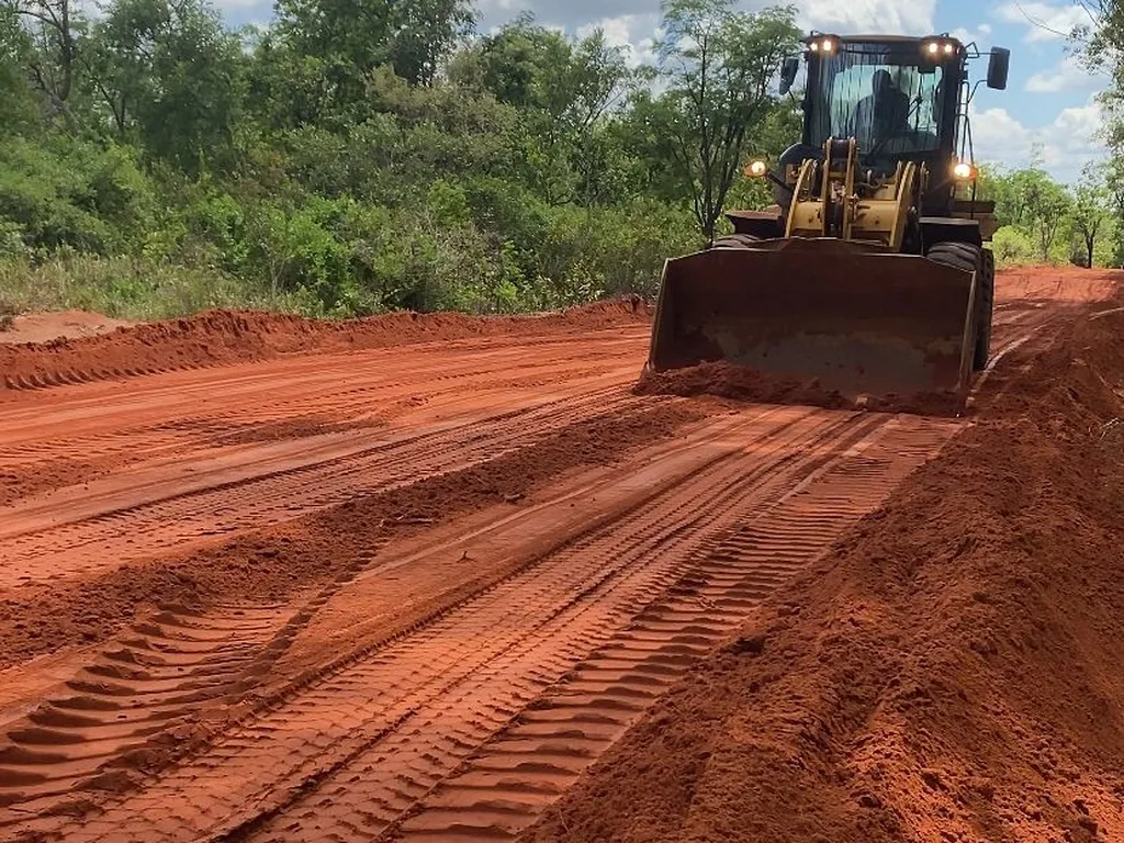 Before — Laterite road under grading and the same route completed with asphalt paving and drainage by HAMAAR Projects